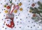 Christmas snowy background with Christmas sock, lollipops, gingerbread, Christmas tree toys, branches, cones.