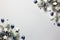 Christmas snowy border of shiny balls and classic blue stars, evergreen branches on neutral pastel grey background