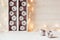 Christmas soft home decor of silver apples and lights burning in boxes on a wooden white background.