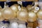 Christmas sparkling balls sold in store. Gold bright glass balls on shelves of large shop. Close up