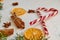 Christmas spices - cinnamon sticks, anise stars, dried oranges with red heart of candy cones and blurred green fir branches