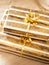 Christmas stack of golden wrapped gift boxes on beige plaid