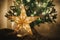 Christmas star on background of christmas tree in lights in evening room. Space for text. Big paper star garland glowing in