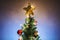 Christmas star on christmas treetop with decorations and colorful lights