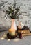 Christmas still life. Burning candle,stack of books, christmas tree, garland on the table