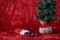 Christmas stocking spilling out coal candy, for bad boys and girls, with a burlap ball artificial tree, on a red background