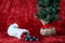 Christmas stocking spilling out coal candy, for bad boys and girls, with a burlap ball artificial tree, on a red background