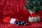 Christmas stocking spilling out coal candy, for bad boys and girls, with a burlap ball artificial tree, on a red background