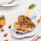 Christmas Stollen cake with icing sugar, marzipan, almonds and raisins on white serving plate