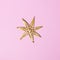 Christmas straw snowflake decoration on pink background. Minimalistic Christmas concept