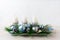 Christmas table centerpiece with three candles and blue ornament