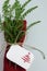 Christmas table decoration, red napkin with healthy herbs and place card with christmass tree