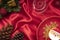 Christmas table decorations with a plate of sugar coated biscuit and a scented candle on bright red silk cloth