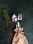 Christmas table place setting, cutlery in burlap bag with festive decorations wooden star, golden bow, pinecone, green branch .