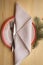 Christmas table place setting with dinner plates, napkin, cutlery, fir