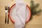 Christmas table place setting with dinner plates, napkin, cutlery, fir