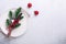 Christmas table place setting with empty white plate, candy canes, fir branch and cutlery with festive decorations on stone