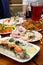 Christmas. Table set, side view.Meats on the holiday table. Sliced salted herring on a white plate with herbs, lemon and olives.