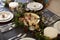 Christmas table setting with bauble name card holders arranged on plates, golden plate centrepiece with baubles, and green and red