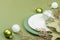 Christmas table setting with ceramic plates, traditional decor on Savannah Green color background