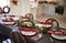 Christmas table setting with Christmas crackers arranged on plates in a dining room, with kitchen in the background