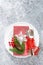 Christmas table setting with empty festive white plate and cutlery with Xmas decorations, snowflake, cone, Xmas tree branches