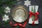 Christmas table setting with vintage dishware, silverware and snowflake decorations on gray linen tablecloth.