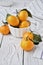 Christmas tangerines in a bowl and next to a white wooden table