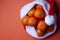 Christmas tangerines in a Santa hat on an orange background, Christmas fruits, festive symbol