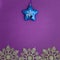 Christmas texture snowflakes and blue christmas toy star on a paper purple