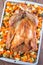 Christmas or Thanksgiving roasted turkey with vegetables, carrot, parsnip, potato on a tray, vertical, top view, closeup