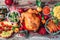 Christmas or Thanksgiving whole roasted chicken, rice, pumpkin, corn, honey, nuts, vegetable salads over wooden background. Top