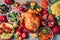 Christmas or Thanksgiving whole roasted chicken, rice, pumpkin, corn, honey, nuts, vegetable salads over wooden background. Top