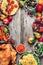 Christmas or Thanksgiving whole roasted chicken, rice, pumpkin, corn, honey, nuts, vegetable salads over wooden background. Top