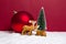 Christmas theme with miniature reindeers, Christmas tree and big bauble on red background
