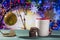 Christmas theme with toy ball, cookies and mug on green wooden surface against nice clock background