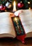 A Christmas-Themed Bookmark In A Well-Loved Book, With A Candle Nearby. Generative AI