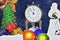 Christmas time. The clock shows the long awaited moment. Coming Santa Claus and unpacking gifts under the Christmas tree.