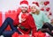 Christmas is time for giving. Loving couple cuddle smiling while unpacking gifts with christmas tree background. Couple