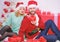 Christmas is time for giving. Loving couple cuddle smiling while unpacking gifts with christmas tree background. Couple