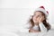 Christmas time, little girl in Santa Claus hat thinking about gifts and presents