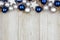 Christmas top border of blue and silver ornaments on gray wood