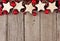 Christmas top border with rustic wood star ornaments and baubles over aged wood