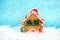 Christmas toy in the form of a gingerbread house on a white snow background. Selective focus