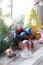 Christmas toy house, balls, cones, branches of spruce, illumination on a wooden surface on a background of a window