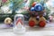 Christmas toy house, balls, cones, branches of spruce, illumination on a wooden surface on a background of a window