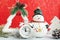Christmas toy snowman, alarm clock, snowflake and tinsel on a red background