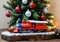 A Christmas Toy Train Under A Tree, With A Front Angle. Generative AI