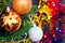 Christmas toys on the Christmas tree on the colorful lighting background. Beautiful glass Christmas decorations. Cool bright New