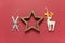 Christmas toys wooden skis, white felt toy deer and wooden hollow star on dark red background. Festive, New Year concept.